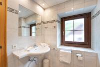 a white bathroom with a sink and a window at Ferienhaus zur Hackenschmiede in Mauterndorf