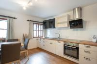 a kitchen with white cabinets and a table and a sink at Ferienhaus zur Hackenschmiede in Mauterndorf