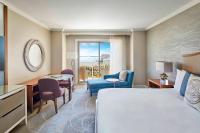 a hotel room with a bed and a desk and chairs at The Ritz-Carlton, Sarasota in Sarasota