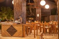 a restaurant with wooden tables and chairs and lights at Hotel Isla Mucura in Isla Mucura