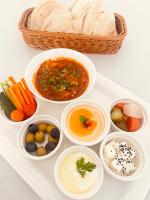 un vassoio pieno di ciotole di diversi tipi di alimenti di Season Inn Hotel Balad Sayt a Rustāq