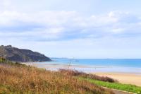 a view of a beach with people in the water at Un cocon face à la mer in Plérin