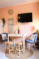 a dining room with a table and chairs and a clock at Un cocon face à la mer in Plérin