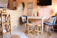 a room with a table and stools and a tv at Un cocon face à la mer in Plérin