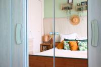 a bedroom with a bed with orange and green pillows at Un cocon face à la mer in Plérin