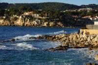 a group of people standing on rocks near the water at Les jardins de Bandol, piscine et mer in Bandol