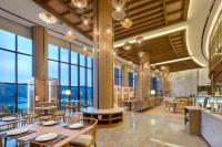 a restaurant with tables and chairs and large windows at Crowne Plaza Zhoushan Seaview by IHG in Zhoushan