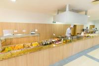 een keuken met een chef-kok die eten bereidt in een cafetaria bij Madara Park Hotel - All Inclusive in Goudstrand