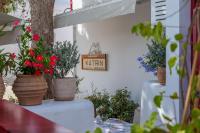 a table with potted plants and a sign on a wall at 23 Hotel Mykonos in Mýkonos City
