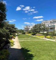 a park with a bench in the grass and buildings at Appartement Hermitage à 10 minutes de Disney in Montévrain