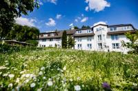a house on a hill with a field of flowers at Landhotel Bellevue in Marburg an der Lahn