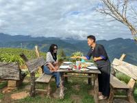 Un hombre y una mujer sentados en una mesa comiendo comida en A Su Homestay Mù Cang Chải, en Mù Cang Chải