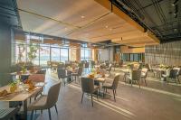 een restaurant met tafels en stoelen in een kamer bij The Code Hotel & Spa Da Nang - Complimentary Daily Afternoon Tea in Sky Bar in Da Nang