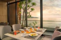 een tafel met eten erop met uitzicht op de oceaan bij The Code Hotel & Spa Da Nang - Complimentary Daily Afternoon Tea in Sky Bar in Da Nang