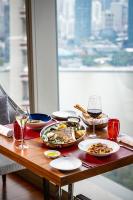上海市にあるザ リッツ カールトン 上海 浦東の食べ物の皿とワインのグラスが置かれたテーブル