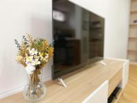 a vase filled with flowers on a table next to a tv at Chez les deux garçons in Montrouge