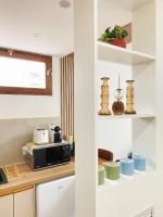 a kitchen with white cabinets and a microwave at Chez les deux garçons in Montrouge