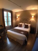a bedroom with a large bed and two windows at Logis Hotel Restaurant la Ferme in Avignon