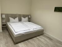 a bed with white sheets and pillows in a room at Hotel Adler in Rudolstadt