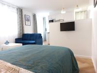 a bedroom with a bed and a blue chair at Cosy &amp; Chic - Hyper centre - Wifi - Proche gare in Châteauroux