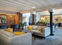 eine Lobby mit Sofas, Tischen und Stühlen in der Unterkunft Delta Hotels by Marriott Worsley Park Country Club in Worsley