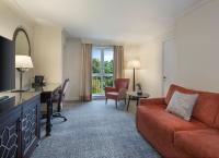 ein Wohnzimmer mit einem Sofa und einem Schreibtisch in einem Zimmer in der Unterkunft Delta Hotels by Marriott Worsley Park Country Club in Worsley