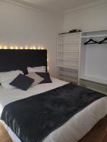 a bedroom with a large bed with a black blanket at L&#39;appartement Idéal 4 voyageurs in Boulogne-Billancourt