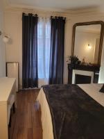 a bedroom with a bed and a mirror and a fireplace at L&#39;appartement Idéal 4 voyageurs in Boulogne-Billancourt