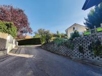 an empty street with a stone retaining wall at Vigny du lac in Publier