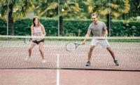 a man and a woman playing tennis on a tennis court at Glamping Bretagne in Quimper