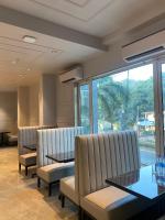 una sala de espera con sillas y mesas y una gran ventana en J Hotel and Banquets, en Bombay