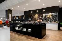 Un restaurante con un bar con platos en exposición. en Four Points by Sheraton Dar es Salaam New Africa, en Dar es Salaam