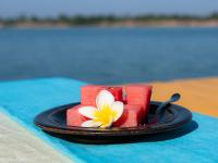 a cake on a plate with a flower on it at Mekong Bird Resort & Hotel in Stœ̆ng Trêng