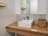 a bathroom with a white sink on a wooden counter at Le Bohème in Sigean