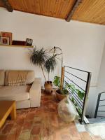 a living room with a couch and potted plants at Le Bohème in Sigean