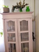 a pink cabinet with a green vase on top of it at Le Bohème in Sigean