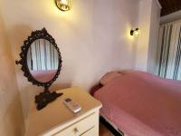 a bedroom with a bed and a mirror on a dresser at Le Bohème in Sigean