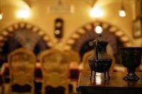 a candle on a table in a church with chairs at Tuya Hotel in Abu Simbel