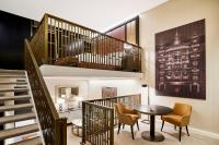 a room with a table and chairs and a staircase at Hilton Budapest in Budapest