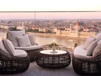a balcony with chairs and a table in front of a window at Hilton Budapest in Budapest