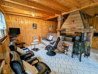 a living room with a stone fireplace in a cabin at Gîte Anould, 4 pièces, 6 personnes - FR-1-589-2 in Anould