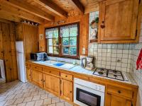a kitchen with wooden cabinets and a stove top oven at Gîte Anould, 4 pièces, 6 personnes - FR-1-589-2 in Anould