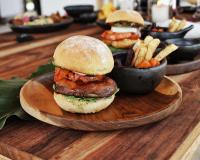 un panino su un piatto di legno con patatine fritte di Hotel Auen Posada Andina a La Unión