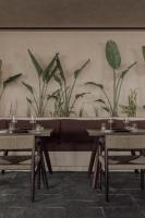 a dining room with tables and plants on the wall at Casa Cook Samos - Adults only in Pythagoreio