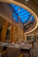 a dining room with tables and chairs and a glass ceiling at Duomo Resort in Shkodër