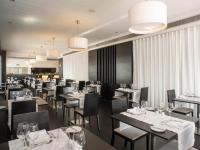 uma sala de jantar com mesas, cadeiras e lustres em Lutecia Smart Design Hotel em Lisboa