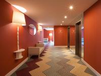 a hallway with orange walls and a room with a chair at Lutecia Smart Design Hotel in Lisbon