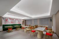 uma sala de jantar com mesas e cadeiras e um quadro em Zhangjiajie Hero Boutique Hotel em Zhangjiajie