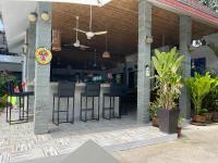a restaurant with a bar with stools on a patio at Lotus Bleu Resort & Restaurant in Rawai Beach