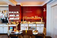 a kitchen with a dining table and a kitchen with red walls at Hotel Bergbauer in Neuburg an der Donau